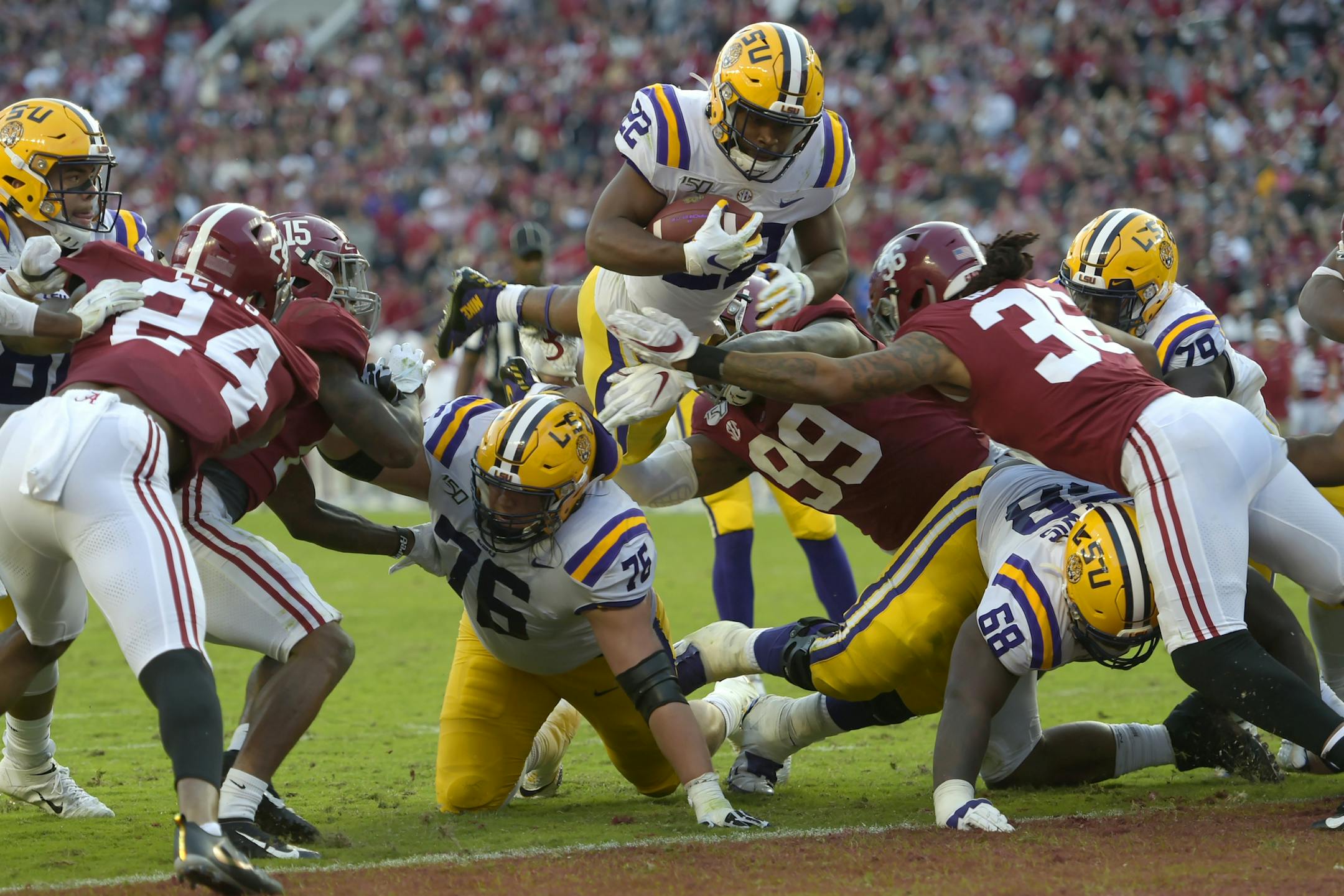 LSU running back Clyde Edwards-Helaire (22) dives over Alabama's Raekwon Davis (99) and Markail Benton (36) to score a touchdown and in the first half of an NCAA college football game, Saturday, Nov. 9, 2019, in Tuscaloosa, Ala. (AP Photo/Vasha Hunt)