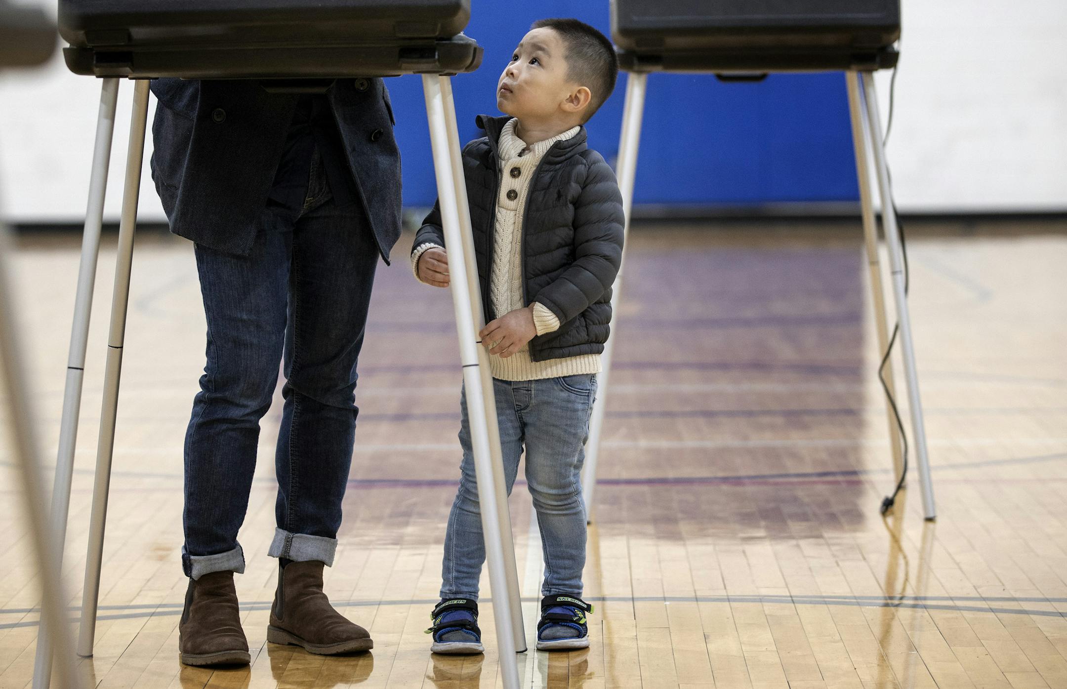 Jayden Nguyen, 3, looked up at his father Donny as he was voting at the Brian Coyle Neighborhood Center in Minneapolis. ] CARLOS GONZALEZ ¥ cgonzalez@startribune.com Ð Minneapolis, MN, November 3, 2020, Election Day