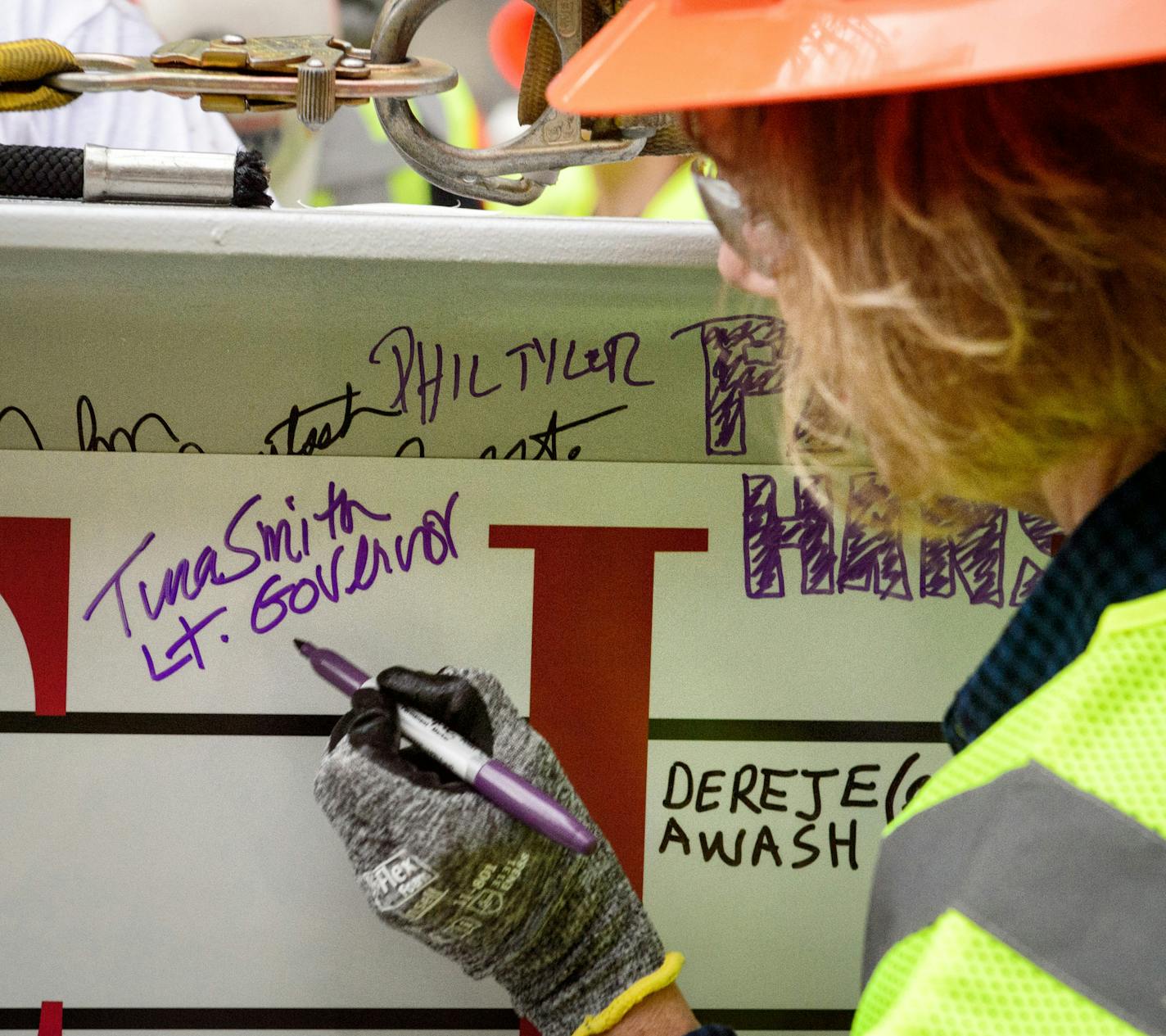 Lt. Governor Tina Smith signed the beam. ] GLEN STUBBE * gstubbe@startribune.com Thursday September 16, 2015 A "topping out" ceremony for the new Minnesota Vikings stadium, marking the highest or last piece of steel placed on a building. Mark Wilf and Lt. Gov. Tina Smith were there. Heavy rain and lightening in the area made it unsafe to hoist the steel beam to the roof. Workers were treated to a free pork chop lunch.