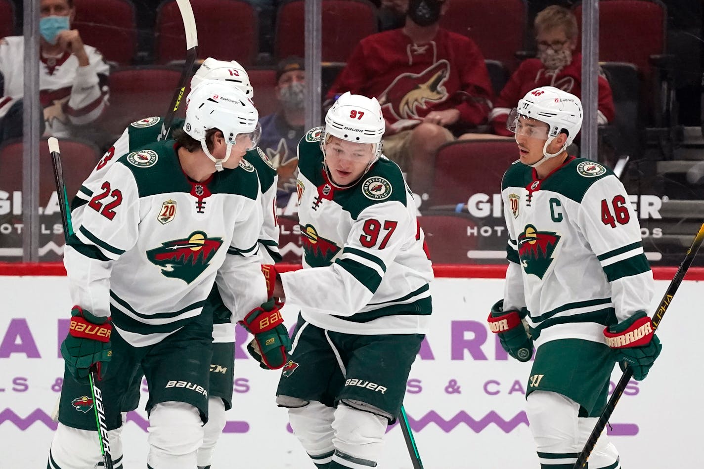 Minnesota Wild left wing Kirill Kaprizov (97) celebrates his goal against the Arizona Coyotes with left wing Kevin Fiala (22), center Nick Bonino (13), and defenseman Jared Spurgeon (46) during the first period of an NHL hockey game Monday, April 19, 2021, in Glendale, Ariz. (AP Photo/Ross D. Franklin)