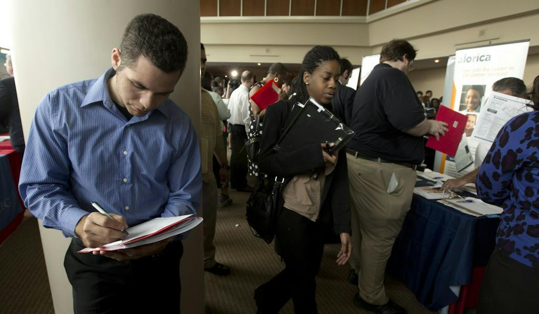 In this Tuesday, Jan. 22, 2013 photo, Fernando Rames answers questions on a job application at the job fair in Sunrise, Fla. U.S. employers added 157,000 jobs in January, and hiring was much stronger at the end of 2012 than previously thought.