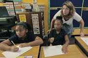 Fourth-grade teacher Laurie Johnson helped Tamia Whittaker Shipp, left, and Samiya Womack, right, with their classwork at Friendship Academy of Fine A
