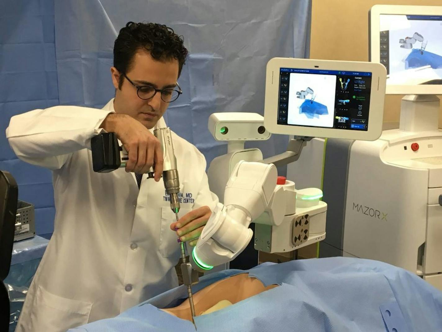 Spine Surgeon Dr. Eiman Shafa of the Twin Cities Spine Center demonstrates the use of Medtronic's Mazor X robotically navigated spine-surgery system Tuesday at Abbott Northwestern Hospital, where he operates on patients using the first such system in the Twin Cities. Shafa showed how the system allows a doctor to plan a surgery and then precisely position surgical tools like this a hand drill, which are still operated by the surgeon. The system, which retails to hospitals for less than $1 millio