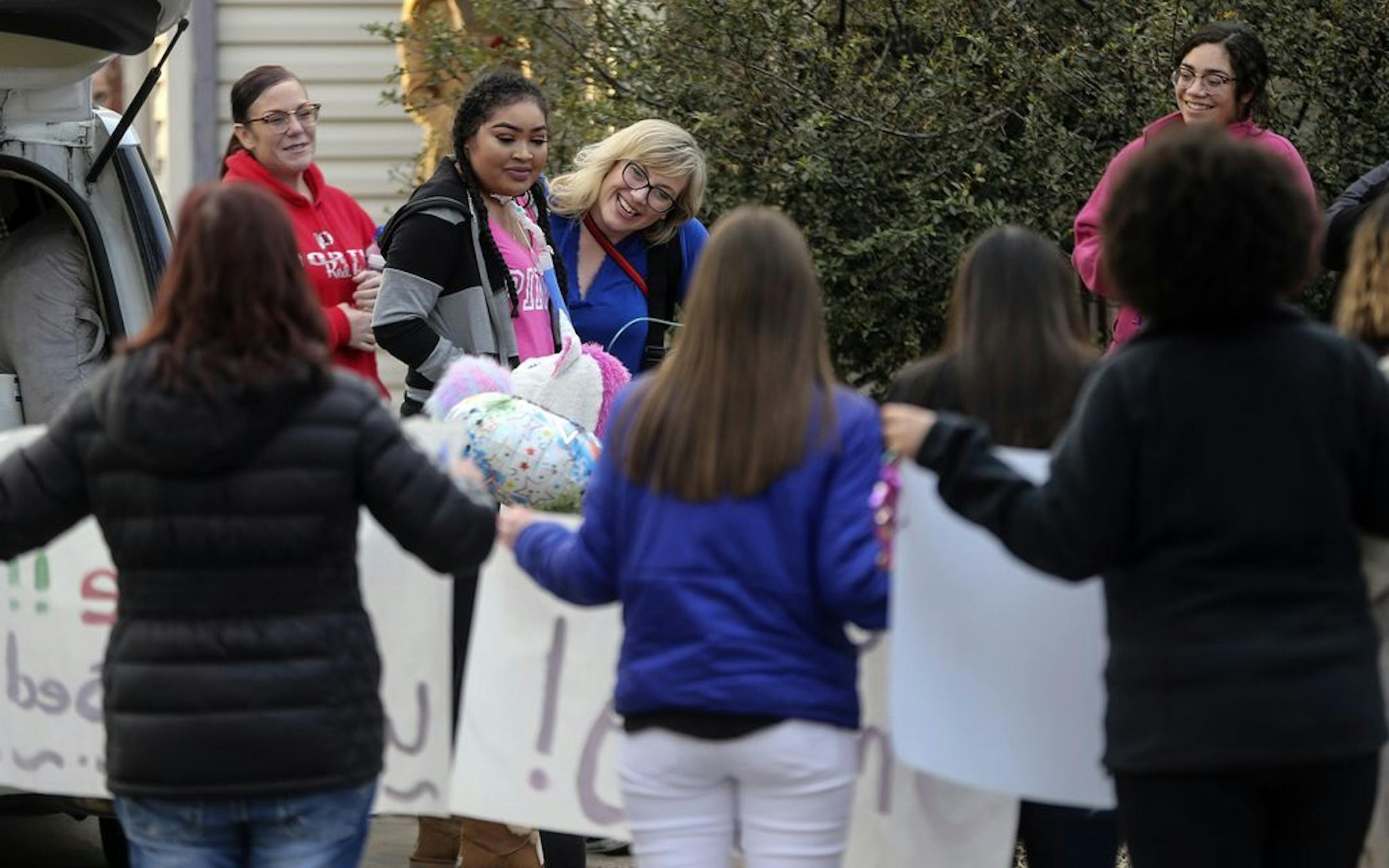 In this Jan. 31, 2019 photo, Zei Uwadia, second from left, is greeted by supporters as she returns to her Wichita, Kan., home, after spending the last 457 days at Children's Mercy hospital in Kansas City following her collapse from a lung condition. Uwadia died in her home on Tuesday, Feb. 12, 2019, her mother said. She was 17.