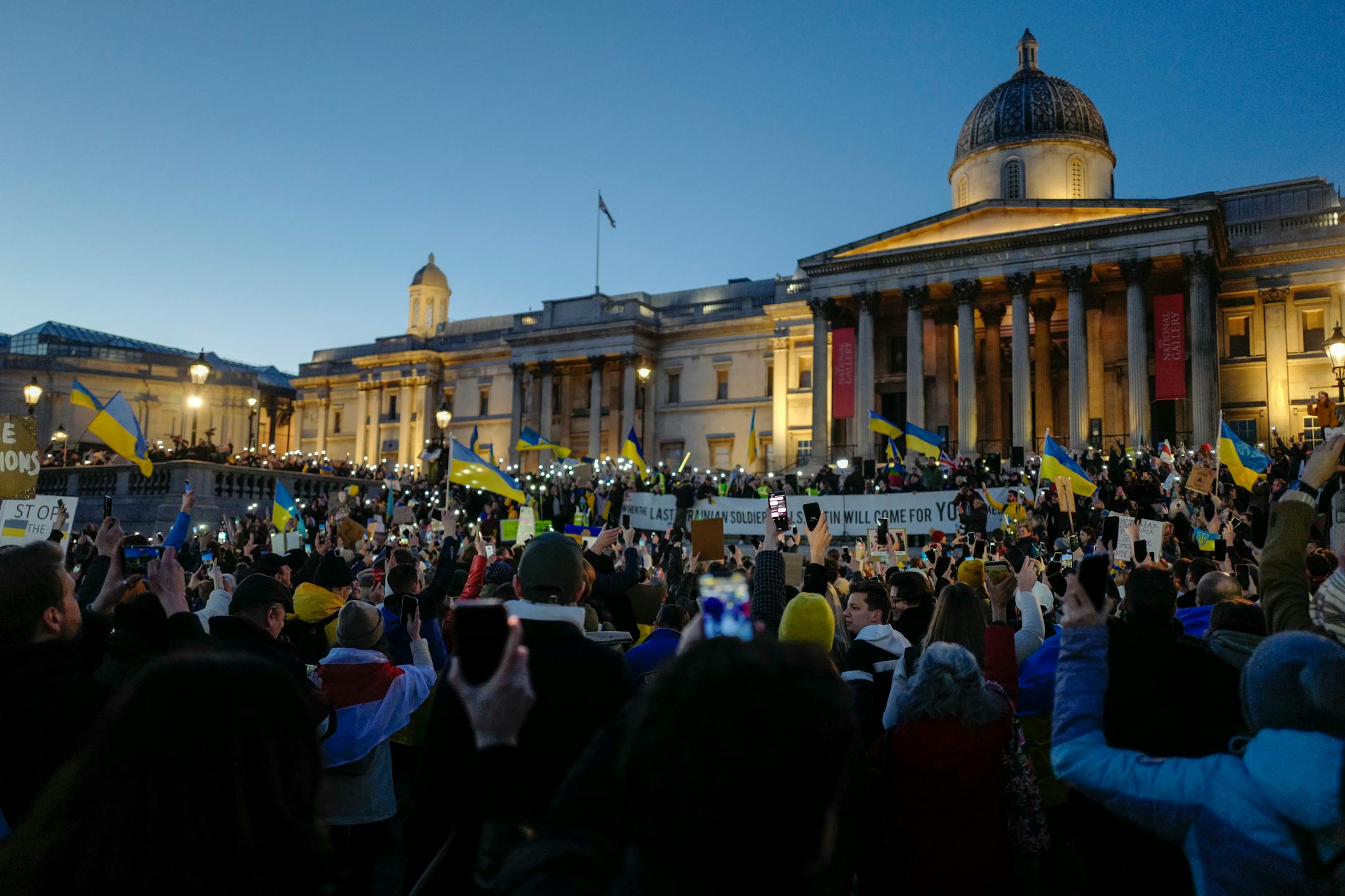 Demonstrators hold placards and Ukraine flags during a protest in Trafalgar Square in London, Sunday, Feb. 27, 2022. A Ukrainian official says street fighting has broken out in Ukraine's second-largest city of Kharkiv. Russian troops also put increasing pressure on strategic ports in the country's south following a wave of attacks on airfields and fuel facilities elsewhere that appeared to mark a new phase of Russia's invasion. (AP Photo/Alberto Pezzali)