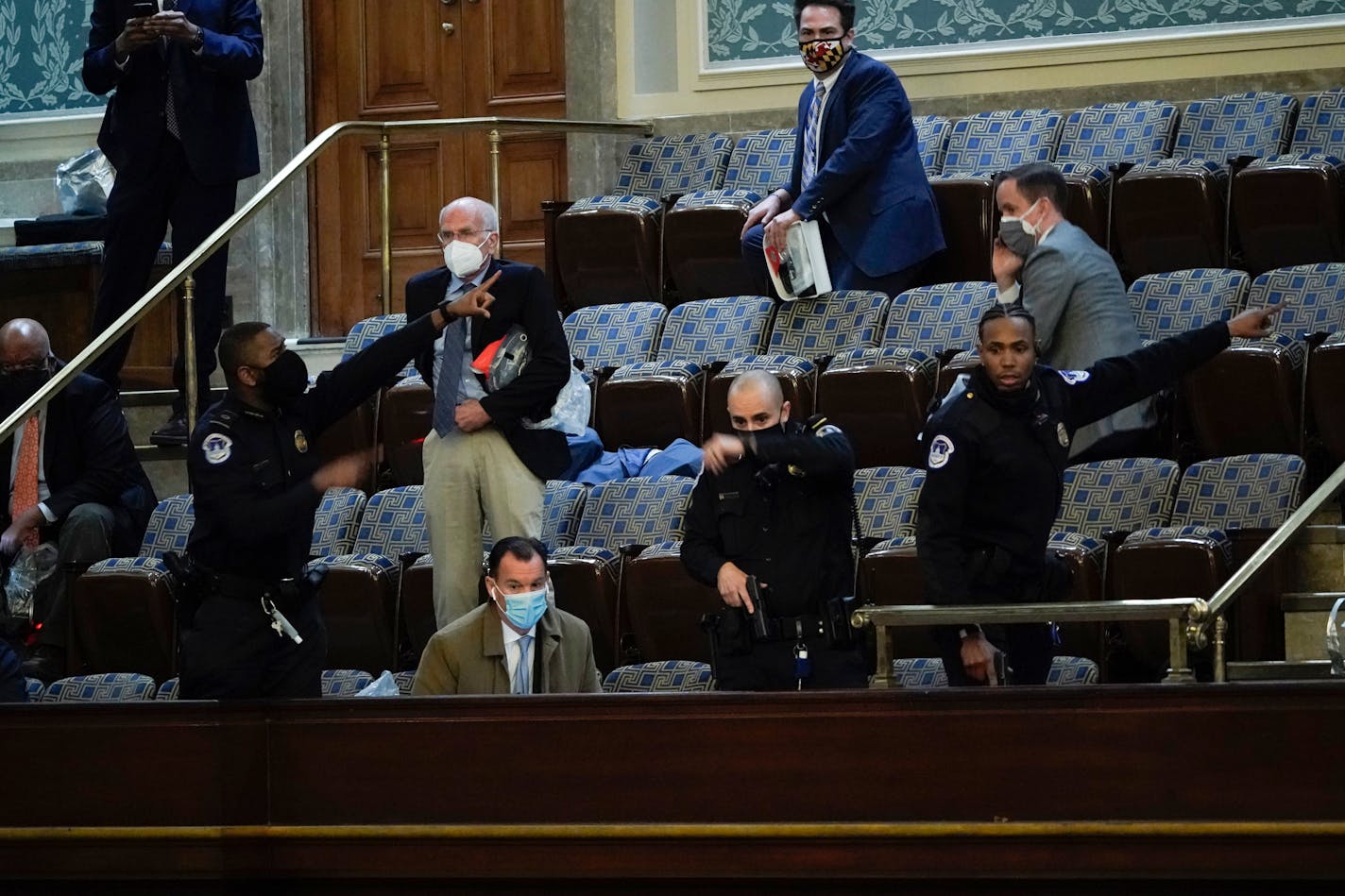 Lawmakers prepare to evacuate the House gallery as protesters try to break into the House Chamber at the U.S. Capitol on Wednesday, Jan. 6, 2021, in Washington.