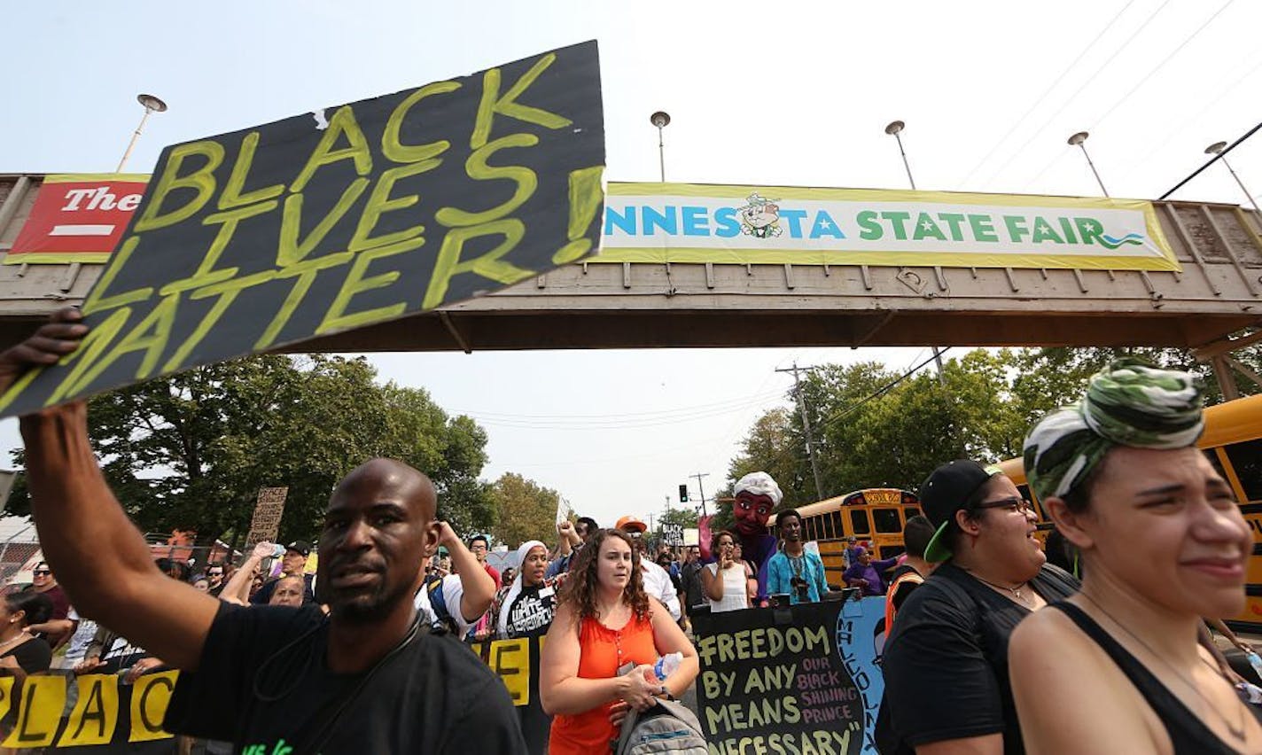 People march during a Black Lives Matter protest near the front gate of the Minnesota State Fair, Saturday, Aug. 29, 2015, in Falcon Heights, Minn. (Jim Gehrz/Star Tribune via AP) MANDATORY CREDIT; ST. PAUL PIONEER PRESS OUT; MAGS OUT; TWIN CITIES LOCAL TELEVISION OUT ORG XMIT: MIN2015083111420315