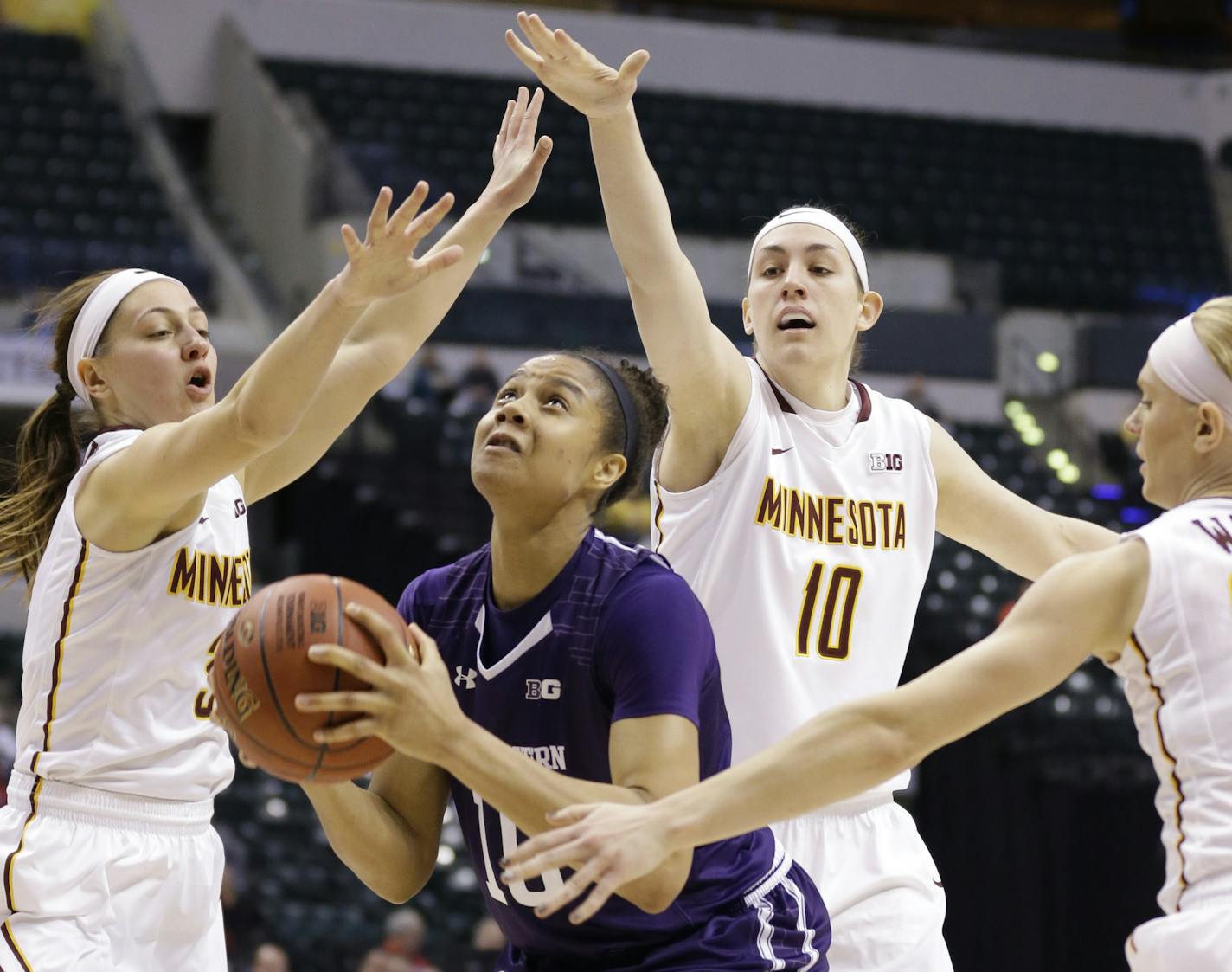 Northwestern forward Nia Coffey (10), center, shoots between, left to right, Minnesota guard Shayne Mullaney (3), center Jessie Edwards (10) and guard Carlie Wagner (33)i n the second half of an NCAA college basketball game at the Big Ten Conference tournament in Indianapolis, Thursday, March 3, 2016. Northwestern defeated Minnesota 84-74. (AP Photo/Michael Conroy)