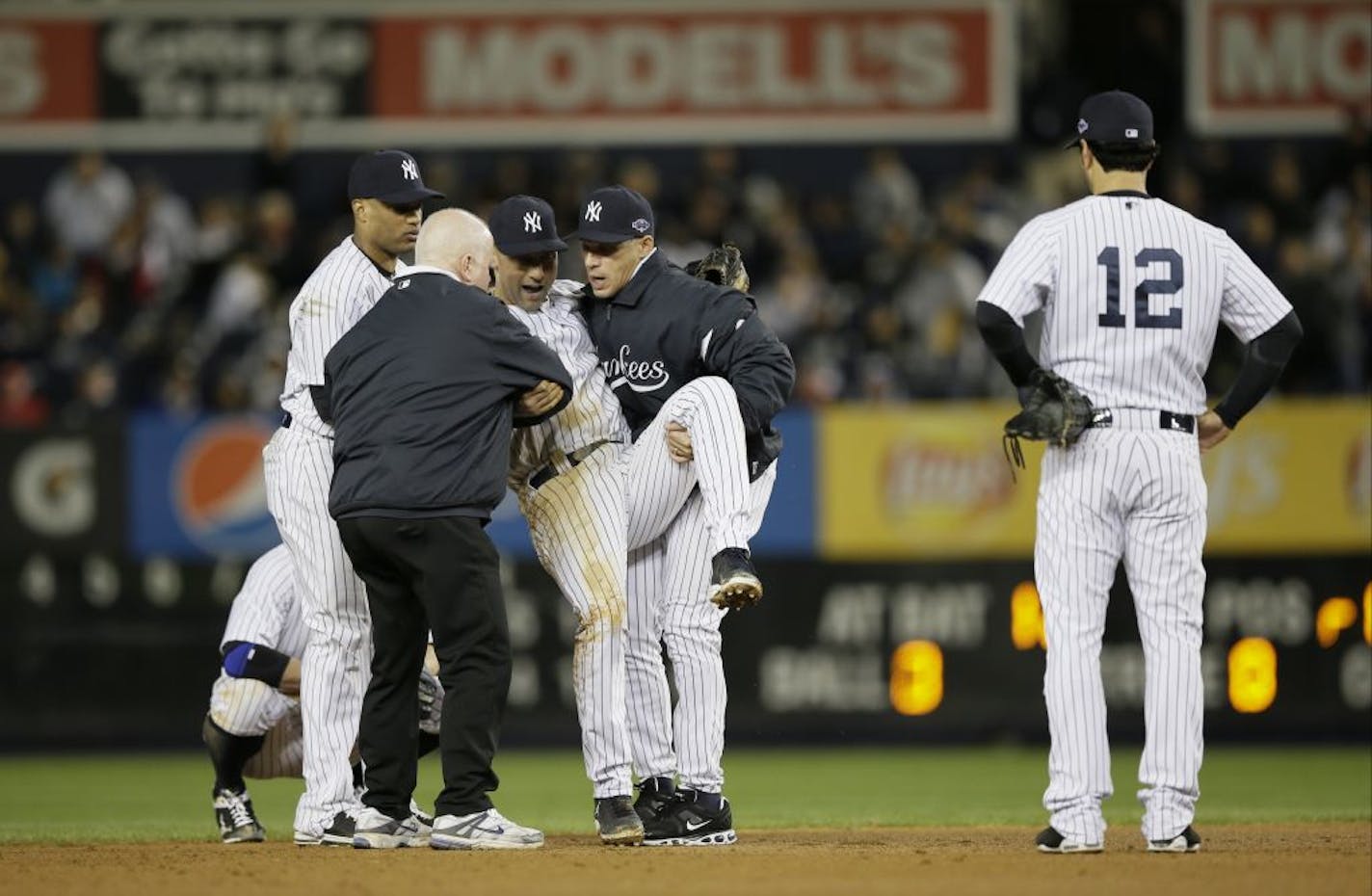 Trainer Steve Donohue, second from left, and New York Yankees manager Joe Girardi, second from right, help Derek Jeter off the field after he injured himself during Game 1 of the American League championship series against the Detroit Tigers Sunday, Oct. 14, 2012, in New York. New York Yankees' Robinson Cano, left, and Eric Chavez stood by.