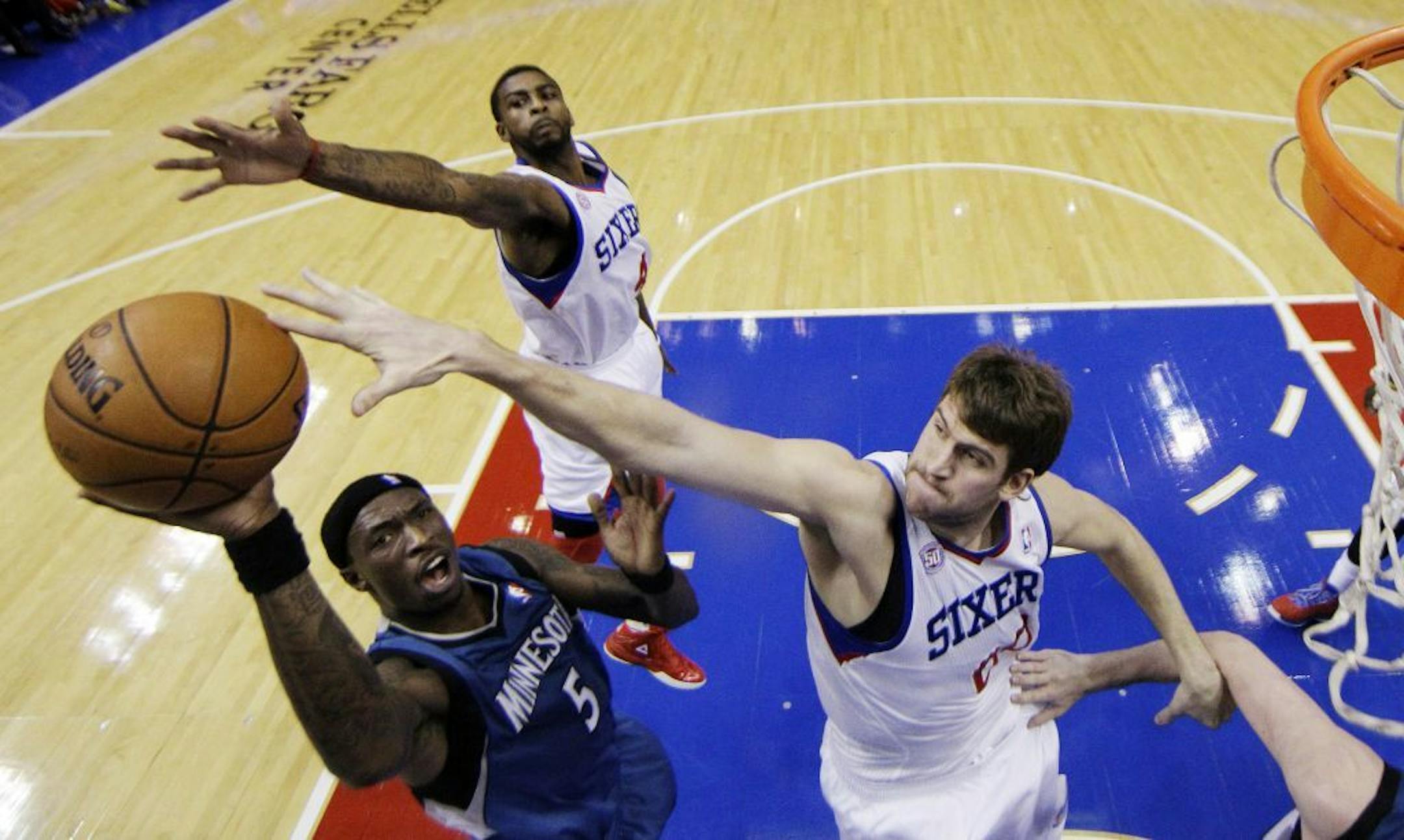 Josh Howard shoots as Philadelphia 76ers' Spencer Hawes, right, and Dorell Wright defend.