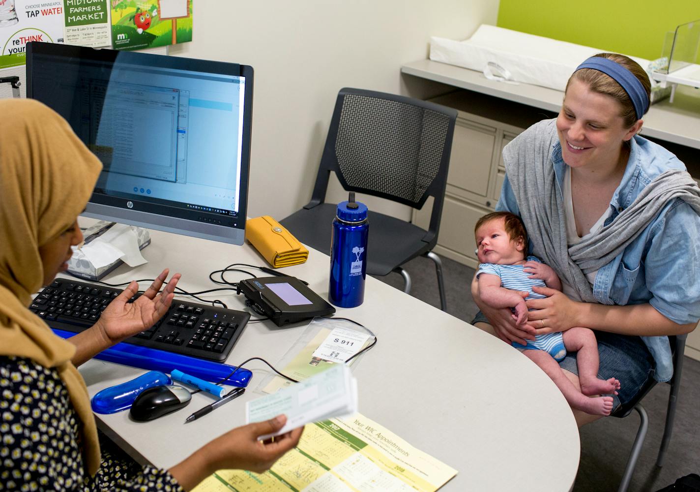 Megan Reid (right) holds her five-week old son, Felix, while speaking to the nutritionist, Lucky Ahmed, as part of the WIC program at the South Hennepin County Human Service Center. ] COURTNEY PEDROZA &#x2022; courtney.pedroza@startribune.com June 16, 2017; Minneapolis; South Hennepin County Human Service Center; now open