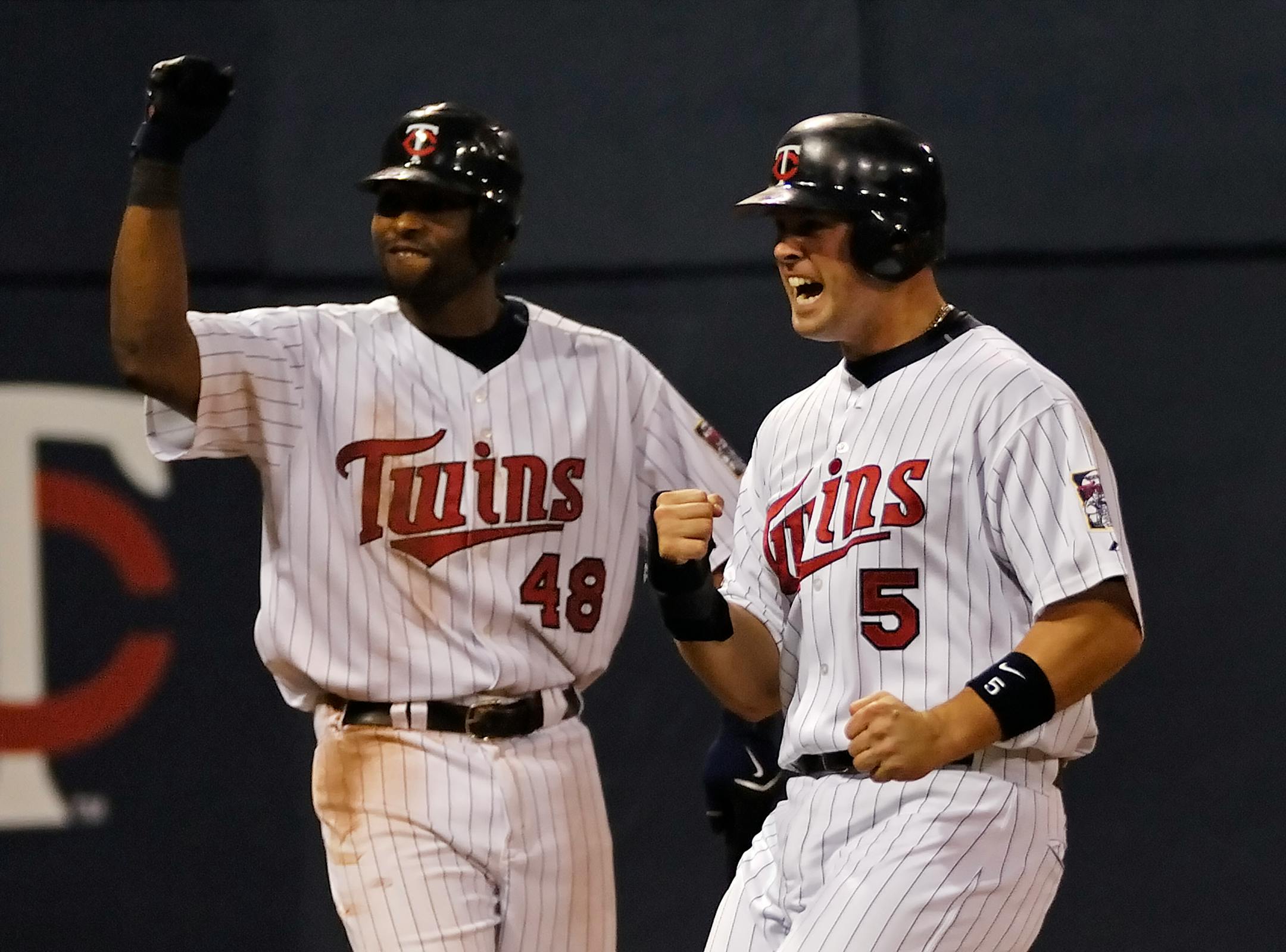 The Good Old Days: Michael Cuddyer celebrates a Justin Morneau double with Torii Hunter in 2006.