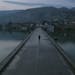 A resident walks across a bridge to the old town of Hasankeyf, Turkey, partially submerged by the Tigris River, Feb. 20, 2020. In his push for economi