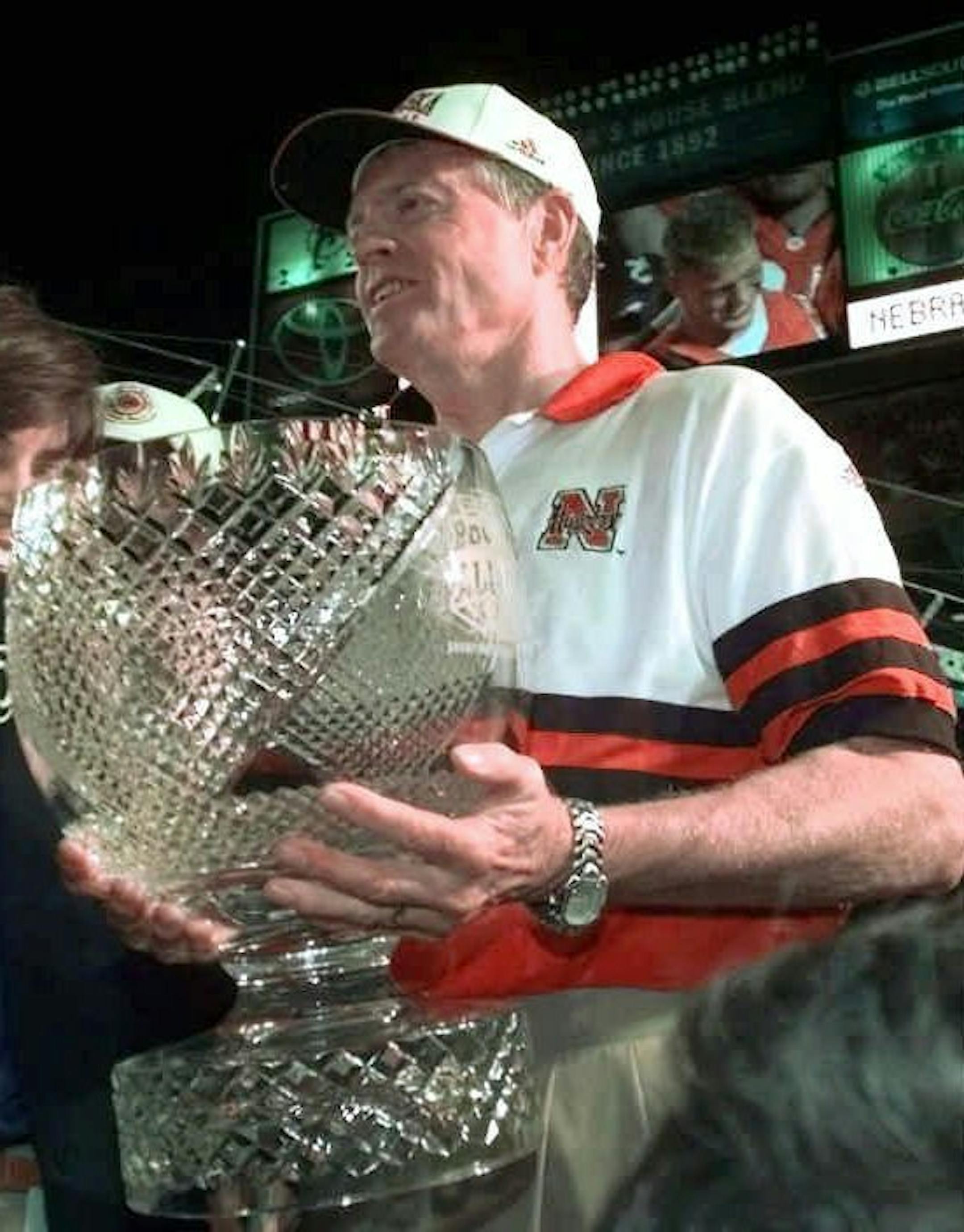 FILE - In this Jan. 2, 1998, file photo, Nebraska coach Tom Osborne holds the Orange Bowl trophy after defeating Tennessee at Pro Player Stadium in Miami. This weekend, players, coaches and staff members from the ’97 team are expected to be on hand for their 20-year reunion, and they’ll attend Saturday night’s, Oct. 7, 2017, game against ninth-ranked Wisconsin. (AP Photo/Susan Walsh, File)