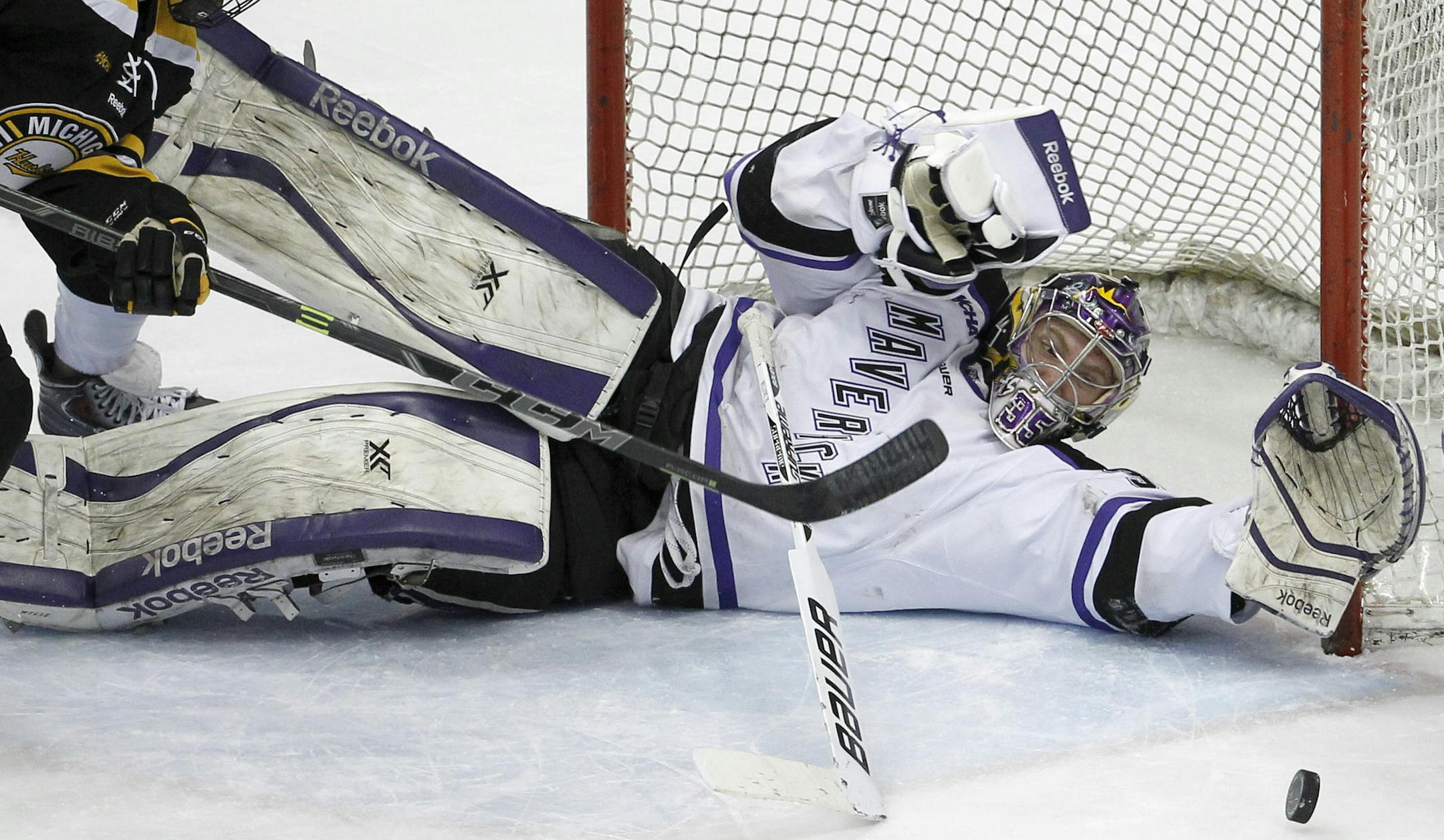 Minnesota State Mankato goalie Stephon Williams, right, dives to stop a shot in front of Michigan Tech forward Alex Gillies (9) and Minnesota State Mankato defenseman Zach Palmquist (7) during the first period of the WCHA Final Five college championship hockey game in St. Paul, Minn., Saturday, March 21, 2015. (AP Photo/Ann Heisenfelt)