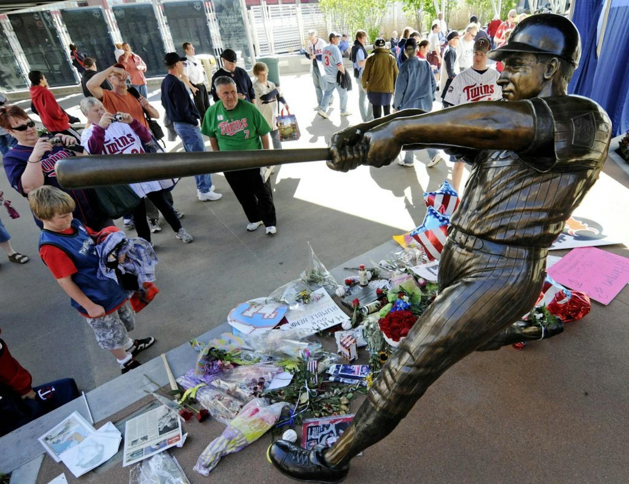 A young boy and other fans stop by the statue of Minnesota Twins Hall of Fame baseball player Harmon Killebrew, Thursday, May 26, 2011, as they arrive at Target Field plaza prior to a public memorial service in Minneapolis for Killebrew who died last week at the age of 74 from cancer in Arizona.