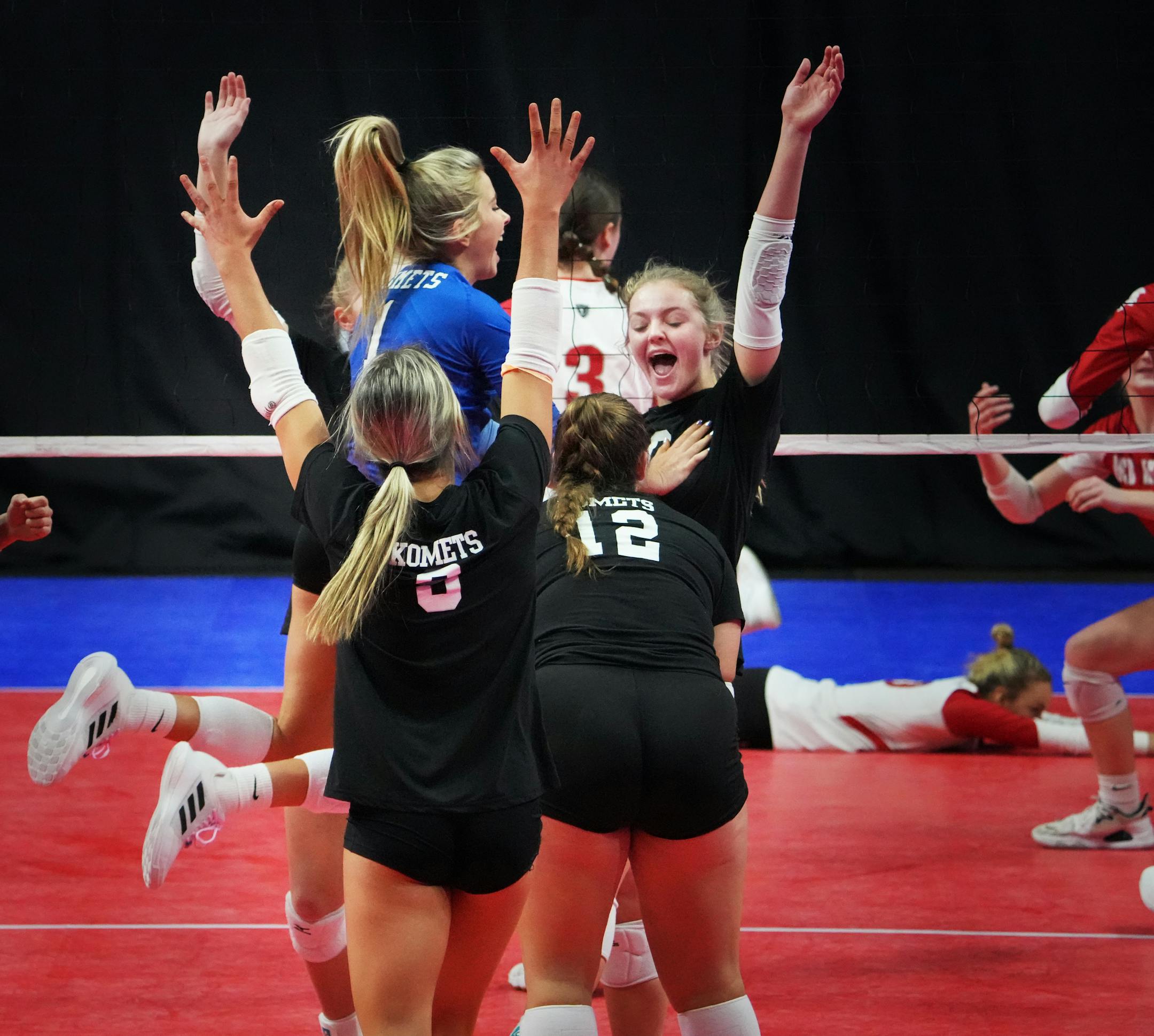 Kasson-Mantorville's Ella Babcock (10) celebrates her point with teammates against Benilde-St. Margaret's.