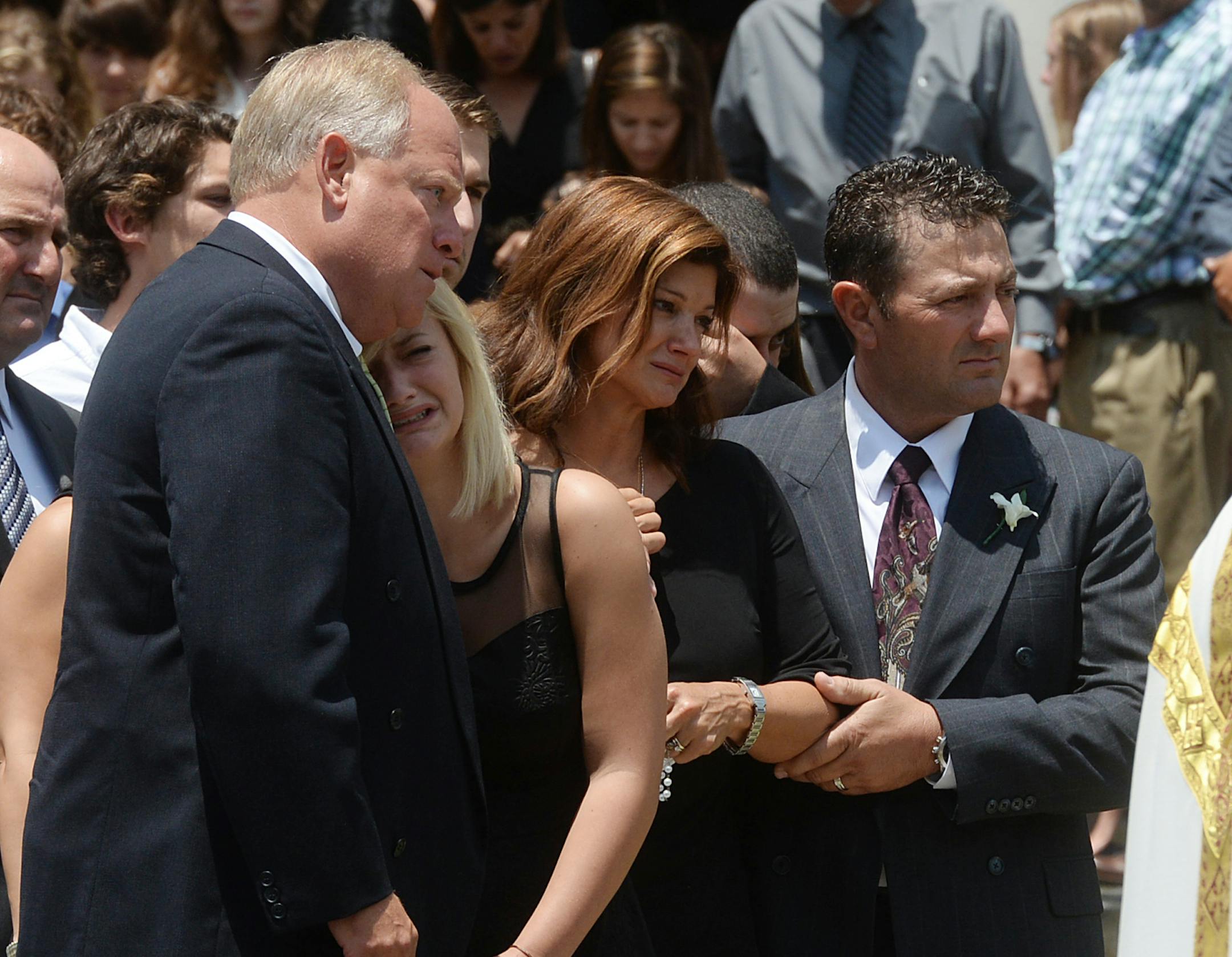 A family member consoles Ali Breaux, second from left, as Dondie LeBanc Breaux, center, and Kevin Breaux, right, stand by while they watch the casket of Mayci Breaux being placed into a hearse following her funeral service at the Church of the Assumption in Franklin, La. (Douglas Collier/The Shreveport Times via AP)