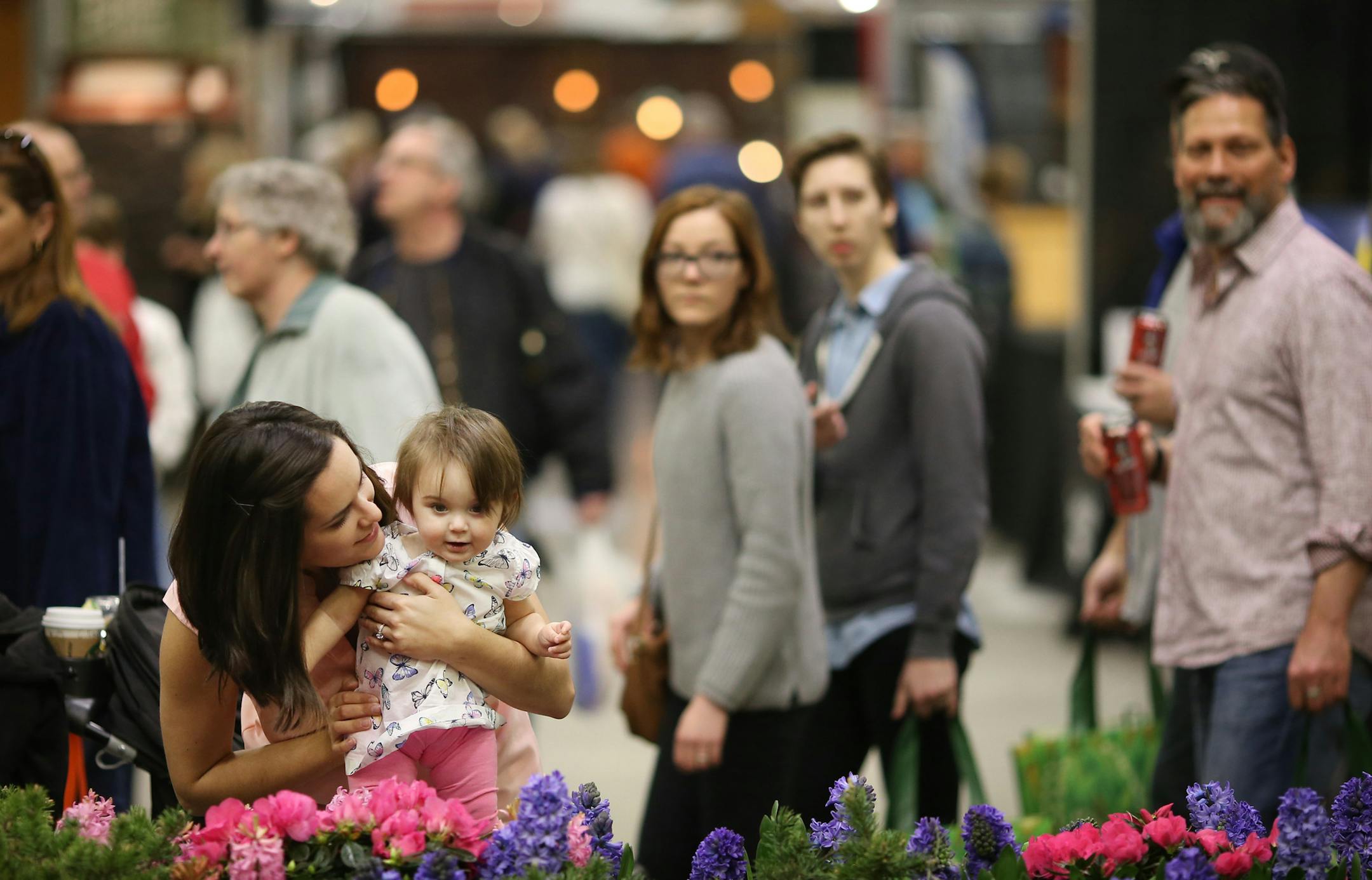 Elizabeth Paulus smelled the flowers with her 10-month old daughter Nora Zimmerman as her fiancÈe John Zimmerman stood nearby during the Home and the Garden Show at the Minneapolis Convention Center Sunday March 6, 2016 in Minneapolis, MN. ] Jerry Holt/Jerry.Holt@Startribune.com