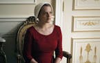 This image released by Hulu shows Elisabeth Moss as Offred in a scene from, "The Handmaid's Tale," premiering Wednesday on Hulu with three episodes. T