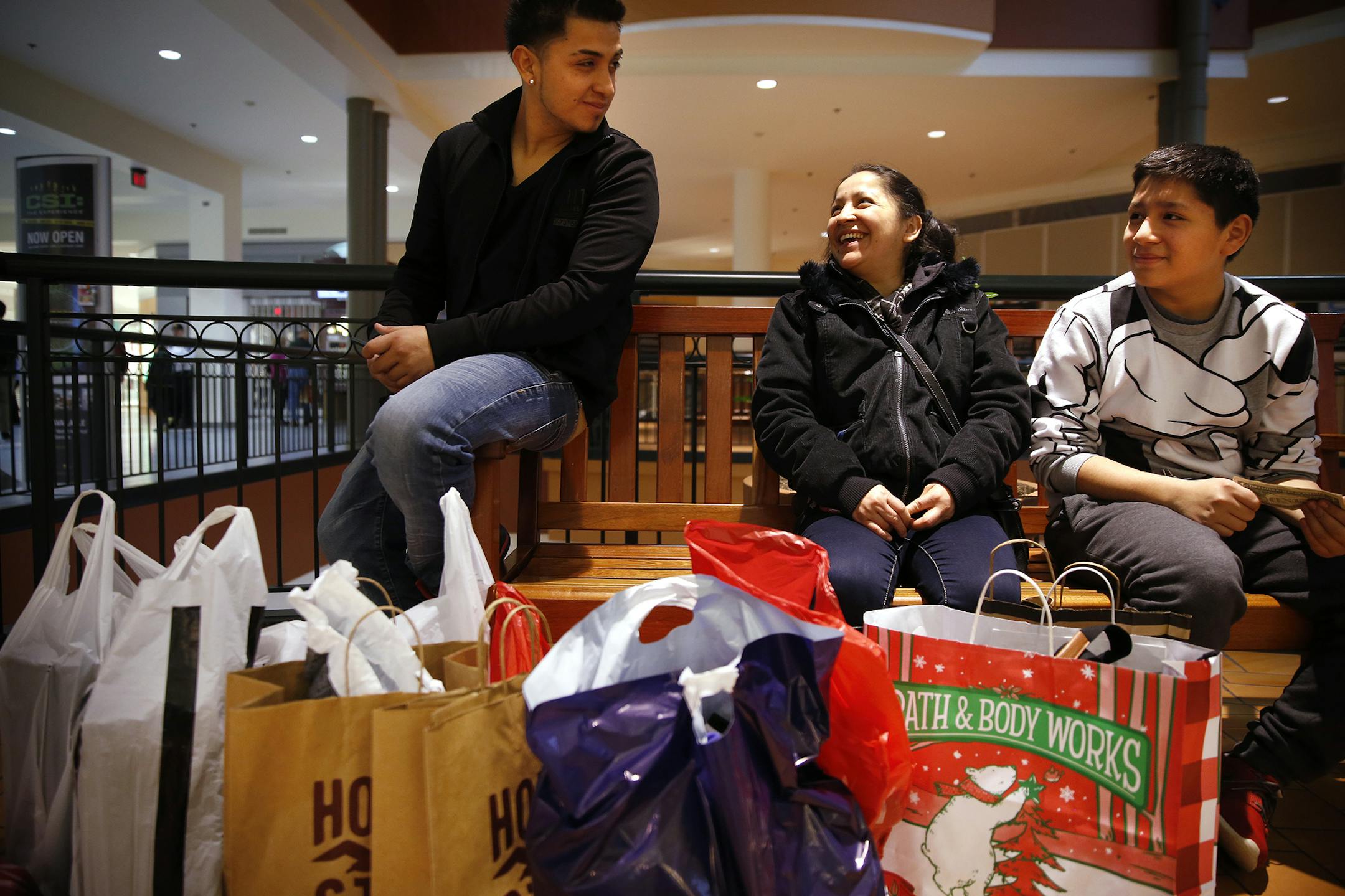 Livia Vasquez, center, of Minneapolis rests while shopping with her sons Jorge Vasquez, left, 20, and Javier Vasquez, 13, at Mall of America in Bloomington on Friday, November 28, 2014. ] LEILA NAVIDI leila.navidi@startribune.com /