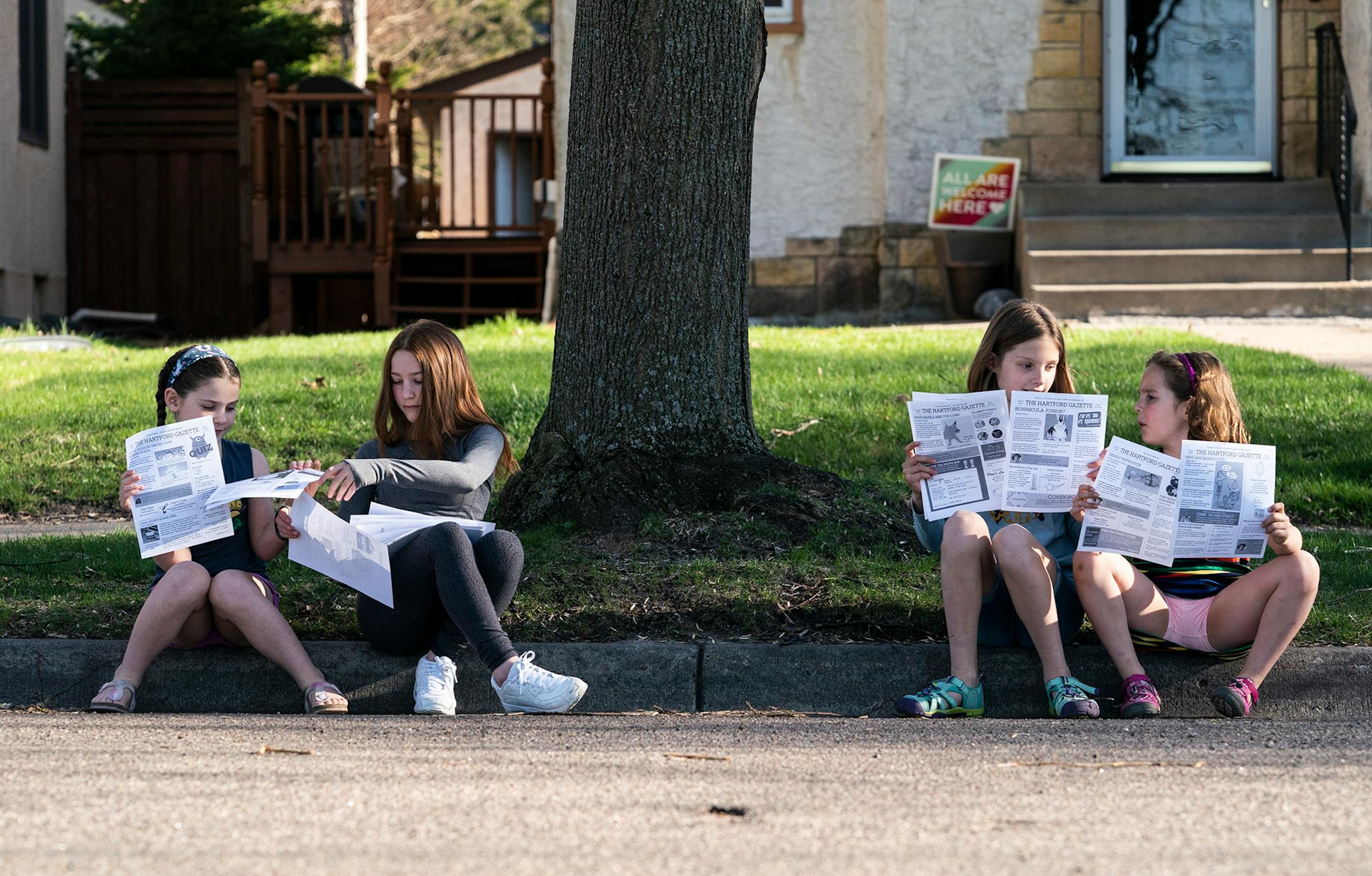 Sisters Cece, 7, and Maddie Pierce, 13, and sisters Clara, 10, and Olivia Plumstead make a daily newspaper that they distribute through their neighborhood in St. Paul, Minn., on Thursday, April 30, 2020.
