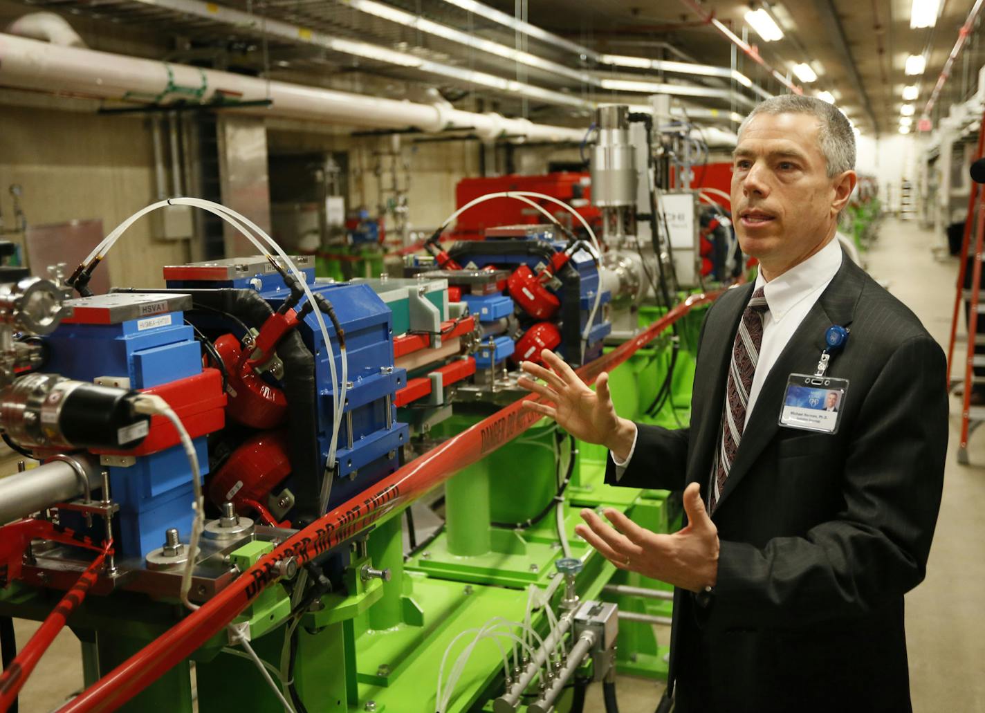 Michael Herman, Ph.D., consultant, Medical Physics, Mayo Clinic in Rochester, led a media tour of the Mayo's New Proton Beam Therapy Facility. Here he stands next to the 200 foot corridor the Proton Beam will travel to the four individual treatament rooms. ] Construction on the Richard O. Jacobson Building, home to the Mayo Clinic proton beam therapy program, is now complete. Over the next 15 months, physicians, scientists and technicians will calibrate and test equipment in advance of the facil