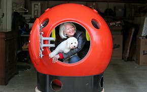 In Ocean Park, on Long Beach Peninsula in Washington state, Jeanne Johnson, with her dog, Trixie, peers out of her two-person tsunami survival pod. Th