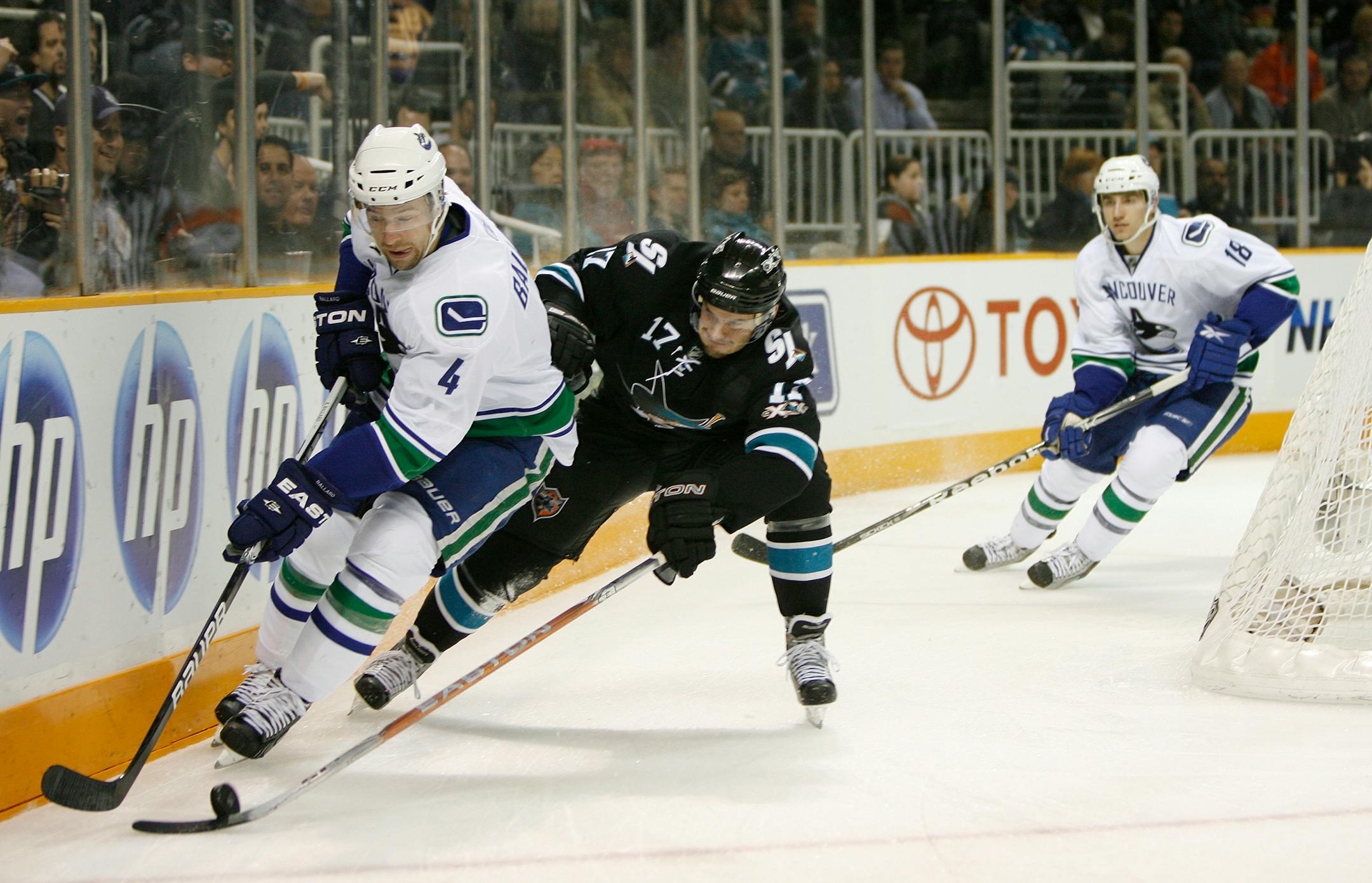 San Jose Sharks' Torrey Mitchell (17) fights for the puck against Vancouver Canucks' Keith Ballard (4) in the first period at HP Pavilion in San Jose, California, on Thursday, March 10, 2011.