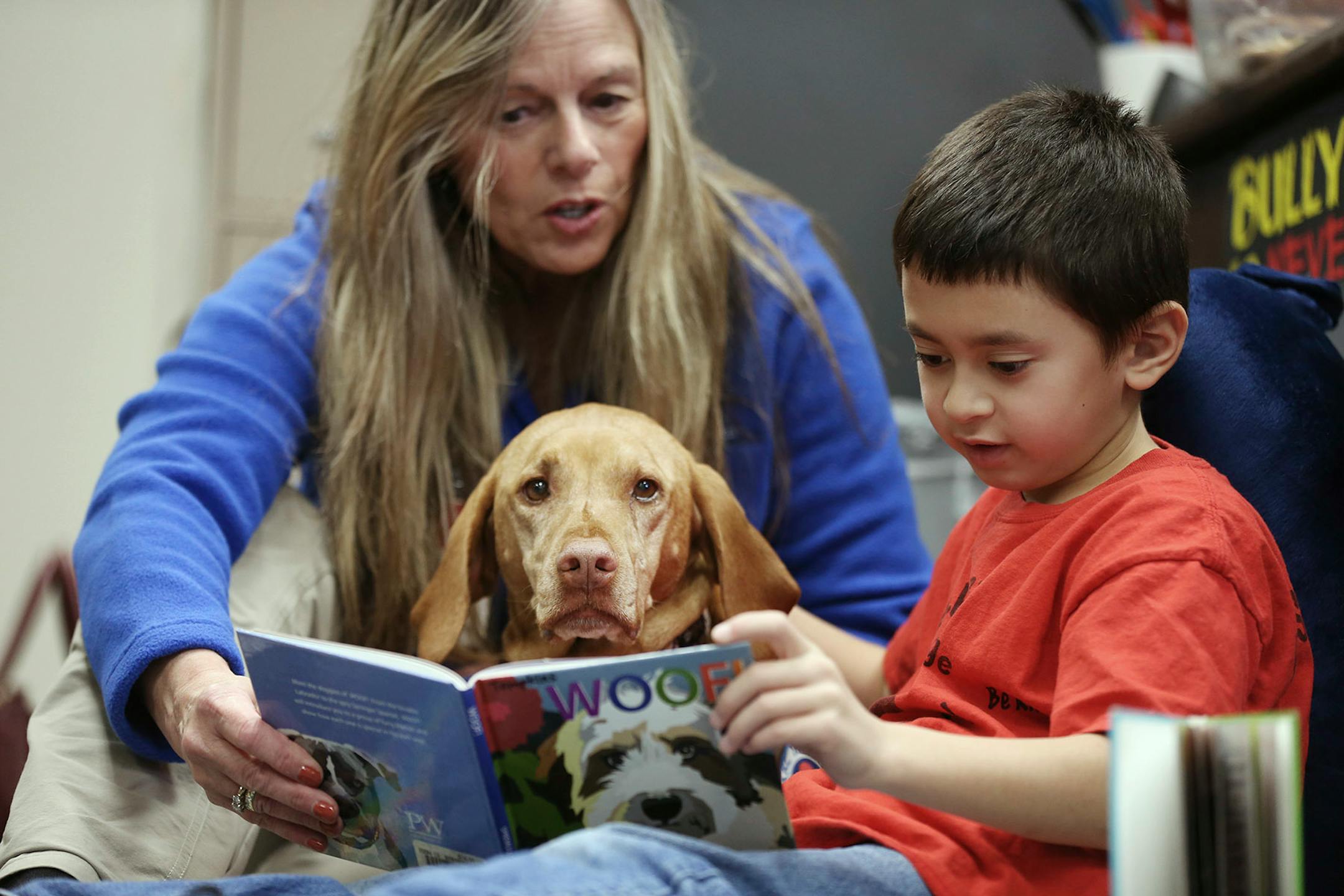Kai Pat 7, read to Molly a Vizsla therapy dog, with her owner Connie Priesz at Cedar Ridge Elementary School Monday October 30,2017 in Eden Prairie, MN.