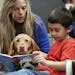 Kai Pat 7, read to Molly a Vizsla therapy dog, with her owner Connie Priesz at Cedar Ridge Elementary School Monday October 30,2017 in Eden Prairie, M
