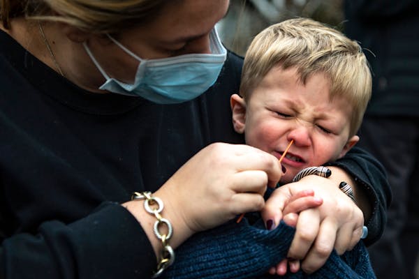 Sarah Glick, helped her son Harrison, 3, by swabbing his nose while getting tested for COVID-19 in Pittsburgh on Tuesday. She said they were getting t