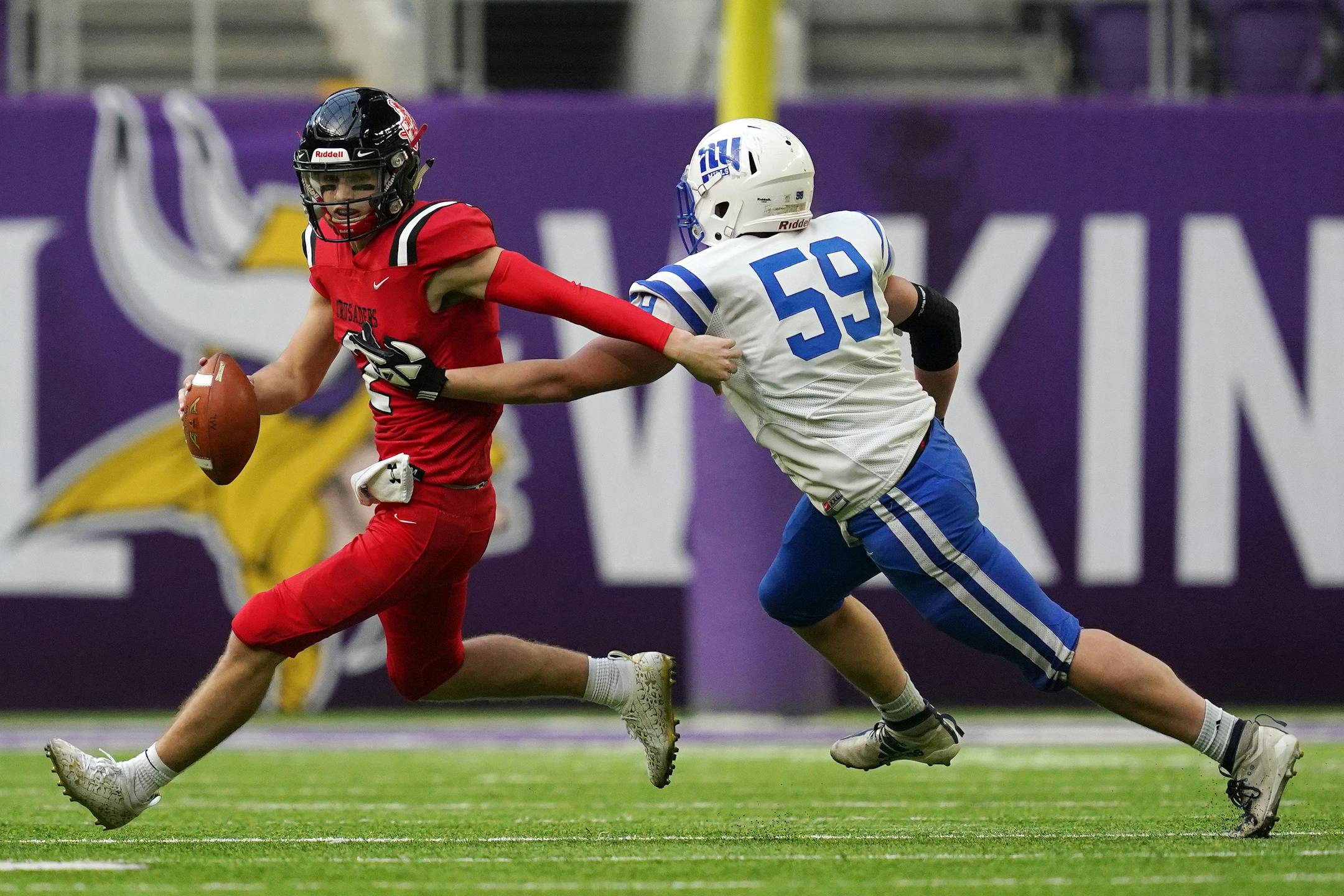 Mayer Lutheran's Ty Hoese (2) rolled out of a tackle by New York Mills' Braeden Peterson (59) in the first half as New York Mills played Mayer Lutheran in a Class 1A semifinal football game Saturday, Nov. 20, 2021 at U.S. Bank Stadium in Minneapolis. ] ANTHONY SOUFFLE • anthony.souffle@startribune.com