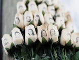 FILE - In this Jan. 14, 2013 file photo, white roses with the faces of victims of the Sandy Hook Elementary School shooting are attached to a telephon