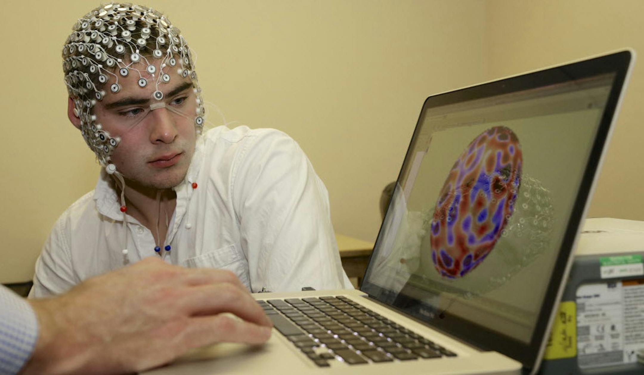 Research assistant Kevin Real wears an EEG net as he looks at his brain activity on a monitor, at the University of Nebraska's Center for Brain, Biology and Behavior in Lincoln.