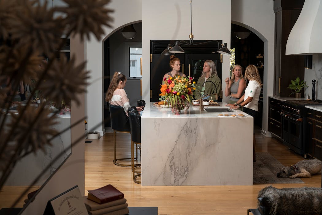 Jayme Moss, far right, entertained friends in the main kitchen of her home in Indianapolis.