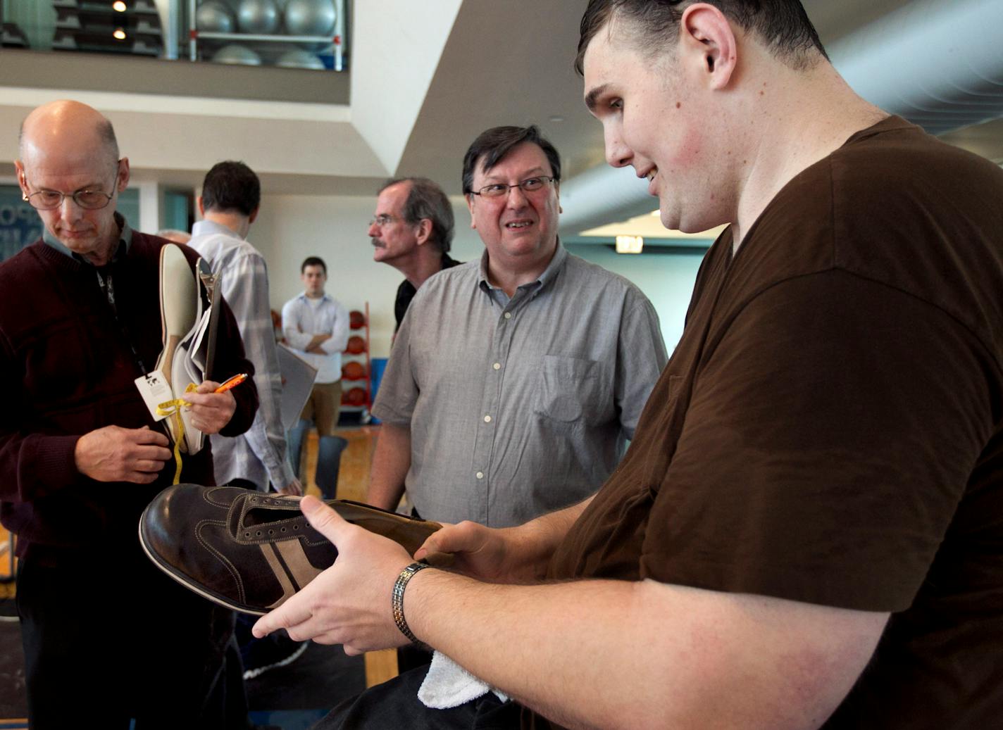 Igor Vovkovinskiy, of Minneapolis, right, currently the tallest man in the United States at seven feet eight inches, speaks with Trevor Kirby, center, a shoe engineer, at Reebok headquarters, in Canton, Mass., Thursday, May 3, 2012. Vovkovinskiy, who has a shoe size between 22 and 26, says he's had 16 surgeries in six years to fix problems created by shoes that didn't fit. Reebok is providing a pair of sneakers to Vovkovinskiy at no charge. (AP Photo/Steven Senne)