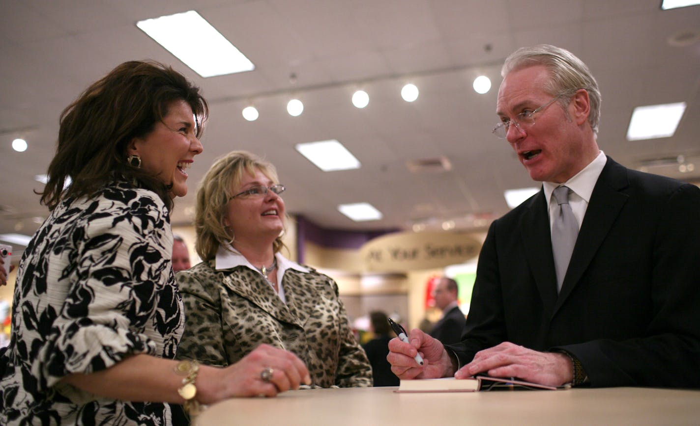 Rachel Schneider, left, and Chick Meek laughed as they visited with Tim Gunn while he signed their copies of his book after the fashion show at Herberger's Wednesday evening.