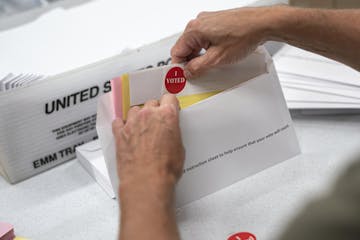 Todd Gallagher prepared mail-in ballot envelopes including an "I Voted" sticker July 29, 2020 in Minneapolis.