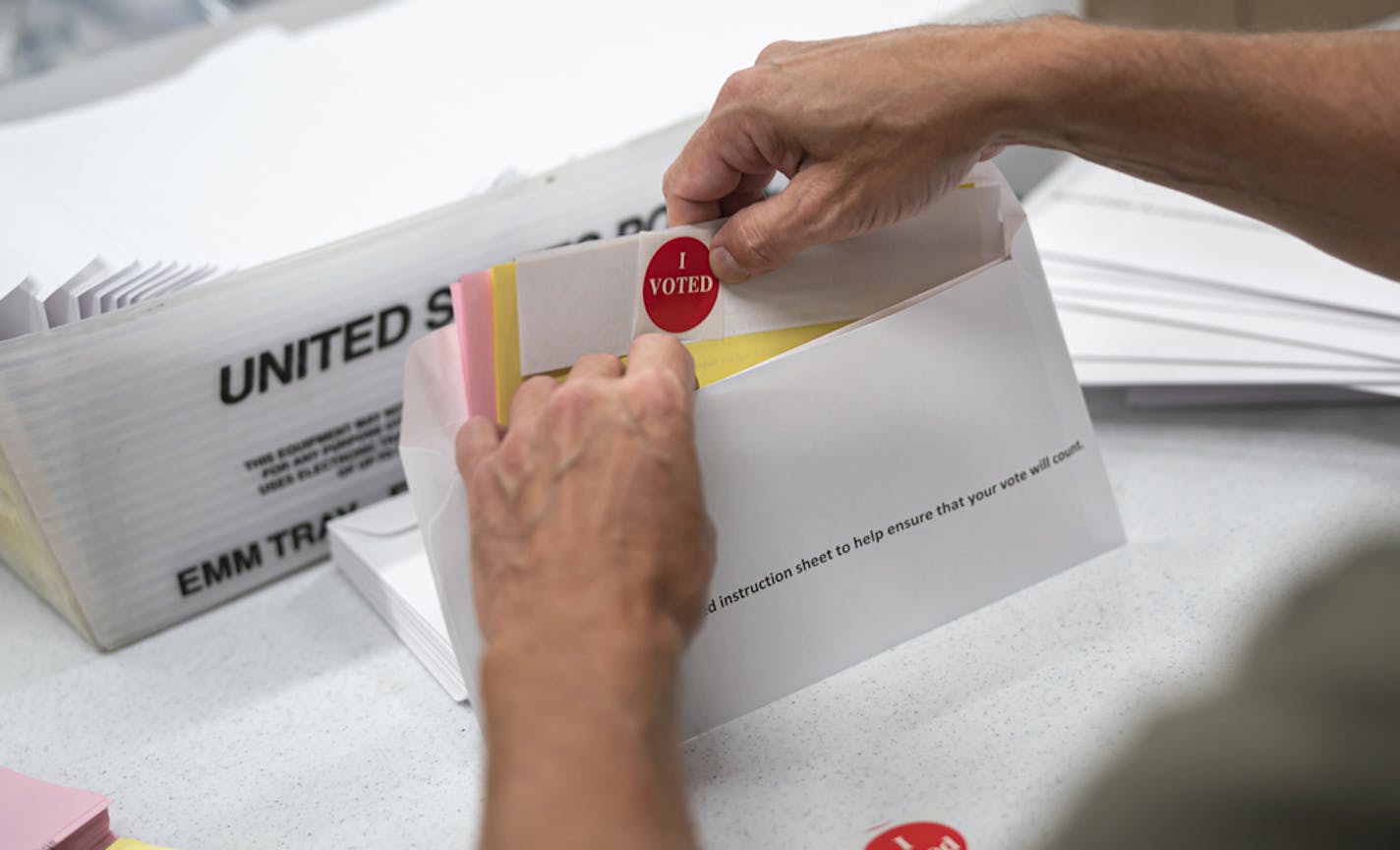 Todd Gallagher prepared mail-in ballot envelopes including an "I Voted" sticker July 29, 2020 in Minneapolis.