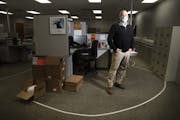 CEO Eric Gibson photographed within the taped recommended distancing lines they have put at work stations at Indigo Signworks in Chanhassen, Minn., on