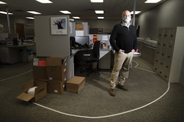 CEO Eric Gibson photographed within the taped recommended distancing lines they have put at work stations at Indigo Signworks in Chanhassen, Minn., on