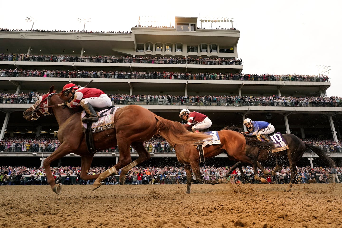 Rich Strike (21), with Sonny Leon aboard, leads Epicenter (3), with Joel Rosario aboard, and Zandon (10), with Flavien Prat aboard in the running of t
