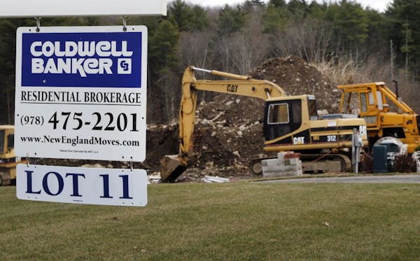 In this Thursday, Dec. 20, 2012 photo, a sign hangs in North Andover, Mass., where a house is under construction. Sales of new U.S. homes cooled off i