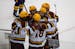 Teammates celebrate with Minnesota forward Jimmy Snuggerud (81) (center) who had just scored his third goal of the game in the third period. The Minne