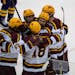 Teammates celebrate with Minnesota forward Jimmy Snuggerud (81) (center) who had just scored his third goal of the game in the third period. The Minne