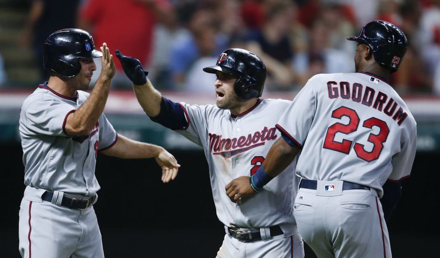 Minnesota Twins' Brian Dozier (2) celebrates with Niko Goodrum (23) and Zack Granite (8) after hitting a three run home run off Cleveland Indians relief pitcher Bryan Shaw during the eighth inning in a baseball game, Tuesday, Sept. 26, 2017, in Cleveland.