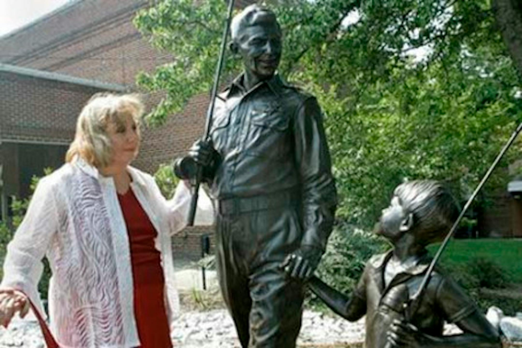 FILE - In a  Sept. 6, 2007 file photo, Betty Lynn, who played Thelma Lou on "The Andy Griffith Show," pauses at a statue of Andy and Opie Taylor in Mount Airy, N.C. Lynn had her wallet stolen at a shopping center in Mount Airy, the birthplace of Andy Griffith, after moving to the area to avoid big city crime. The Mount Airy News reports that police arrested Shirley Walter Guynn, of Cana, Va. in the robbery. (AP Photo/Gerry Broome, File)