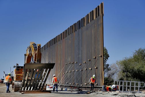 FILE - In this Sept. 10, 2019 file photo, government contractors erect a section of Pentagon-funded border wall along the Colorado River in Yuma, Ariz. Defense officials say the Department of Homeland Security has asked the Pentagon to fund the construction of 270 miles of border wall this year as part of a counter-drug effort. (AP Photo/Matt York) ORG XMIT: WX101