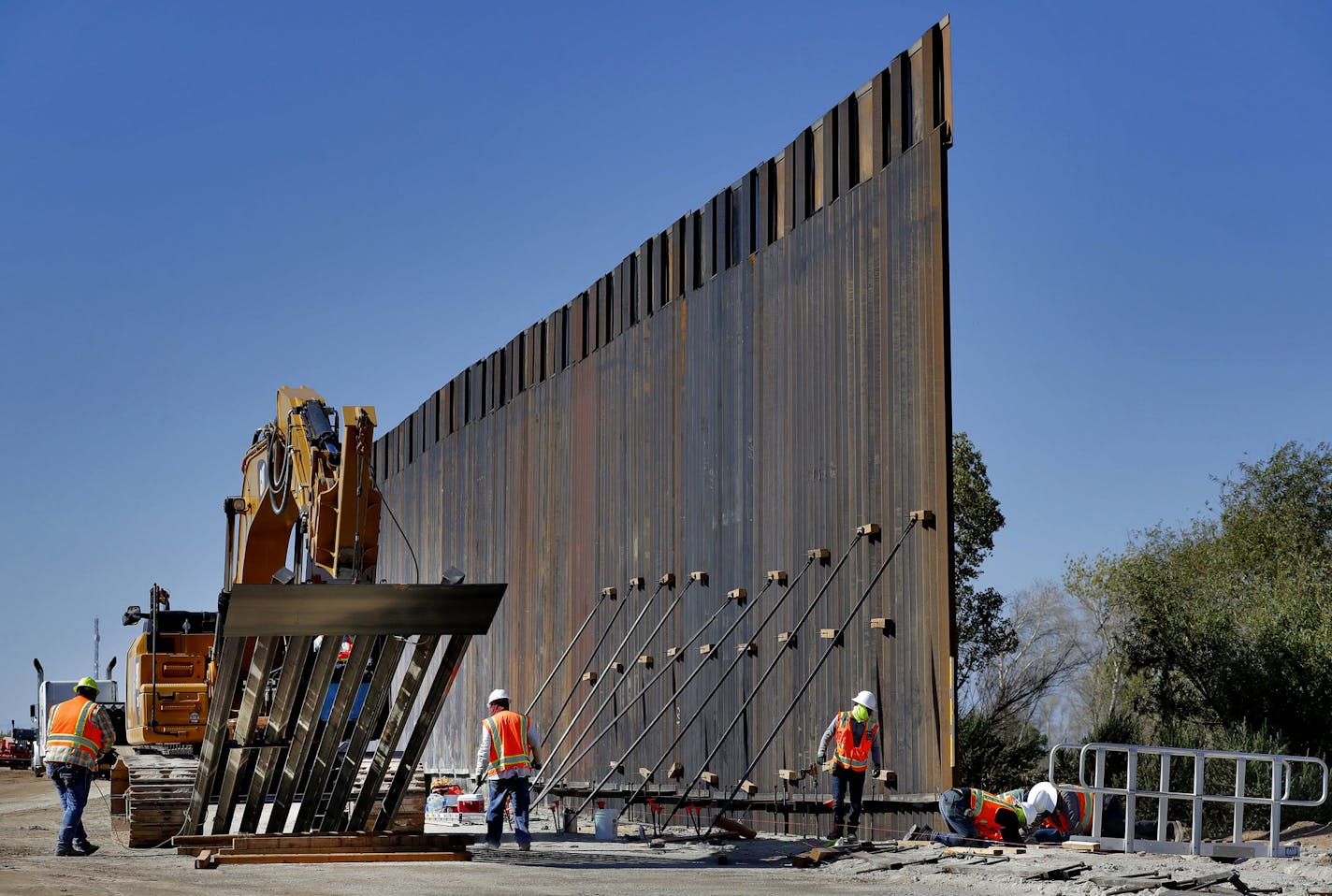 FILE - In this Sept. 10, 2019 file photo, government contractors erect a section of Pentagon-funded border wall along the Colorado River in Yuma, Ariz. Defense officials say the Department of Homeland Security has asked the Pentagon to fund the construction of 270 miles of border wall this year as part of a counter-drug effort. (AP Photo/Matt York) ORG XMIT: WX101